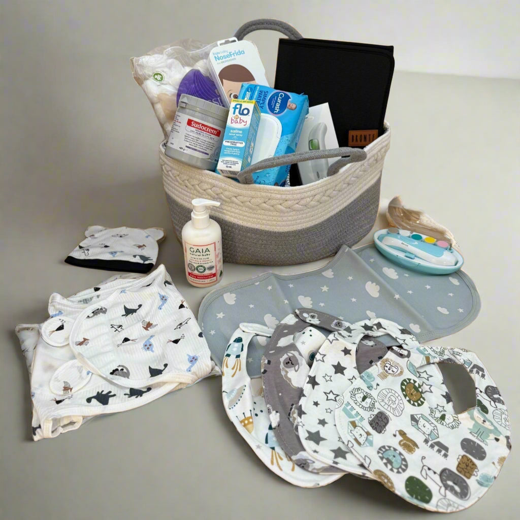 Baby care products including bibs, burp cloths, and bottles on a wooden surface.